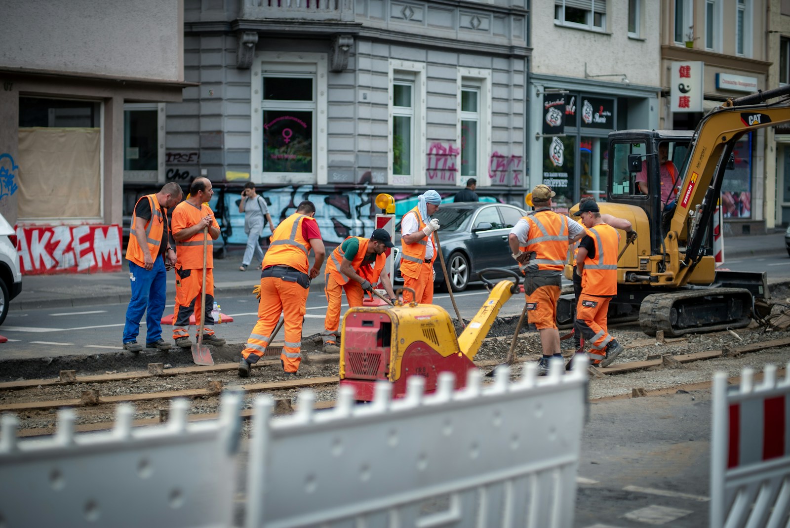 Photo by Mika Baumeister group of men in orange suit standing near building during daytime